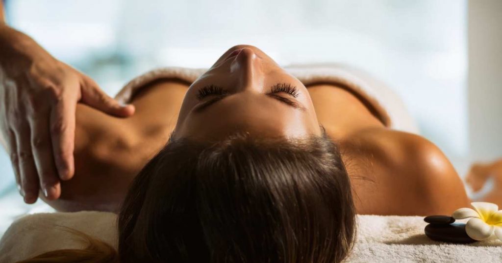 Mujer en spa recibiendo masaje relajante con aceites